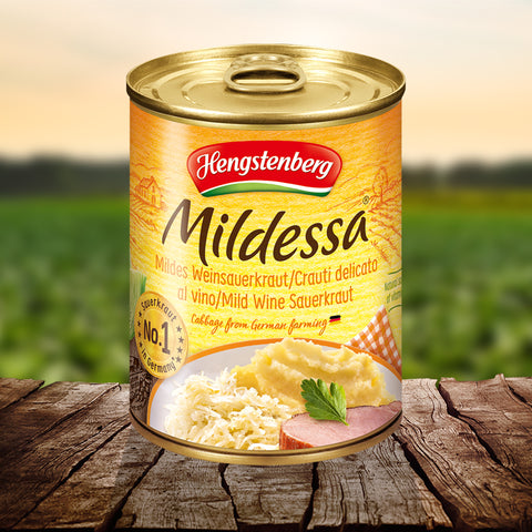 Hengstenberg Mildessa can on a wooden surface with a blurred green field background